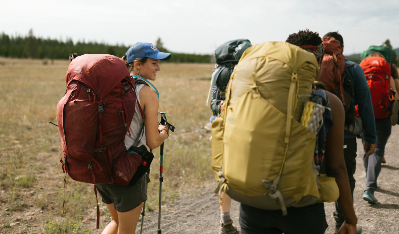a group of people backpacking up a hill